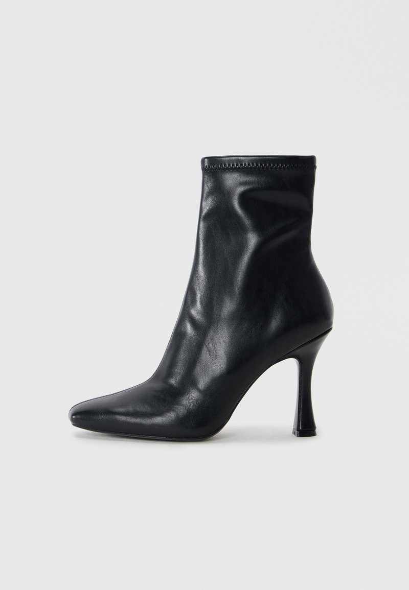 Black leather ankle boot with a pointed toe, fitted silhouette, and a high stiletto heel. Smooth texture and minimal stitching detail.