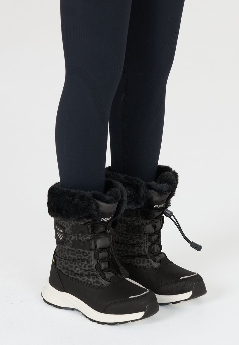 Schwarze und graue Schneestiefel mit einem Leopardenmuster, Kunstfellbesatz und strukturiertem Stoff, verfügen über eine weiße Sohle und eine Schnürverschluss.