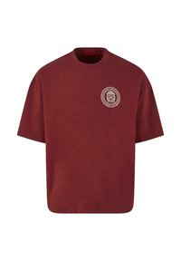 Burgundiškos spalvos medvilninė marškinė su trumpomis rankovėmis, apvaliu iškirpimu ir apskritu grafinio logotipo piešiniu ant krūtinės. Minkšta tekstūra ir laisvas siluetas.