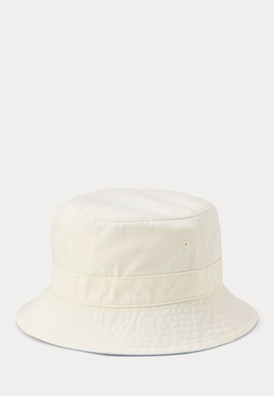 Chapeau bob en coton blanc cassé avec bord cousu et œillets de ventilation sur un fond clair uni.
