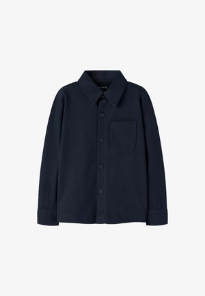 Donker marineblauwe blouse van zachte stof, met een klassieke kraag, lange mouwen, een enkele borstzak en zwarte knopen.