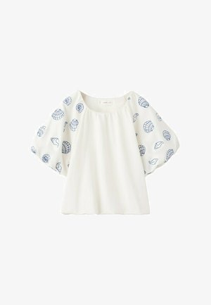 Blouse blanche à manches courtes bouffantes avec broderie de coquillages bleus et col rond.
