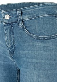 Helle blaue Jeans aus Denim mit geradem Schnitt, ausgestattet mit einer Vordertasche, Nieten-Details und subtiler Verwaschung.