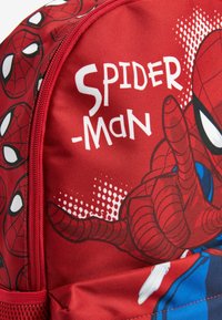 Roter Rucksack mit Spider-Man-Design, versehen mit Spinnennetzmustern und kräftigen Grafiken. Hergestellt aus Textilmaterial mit einem Reißverschluss.
