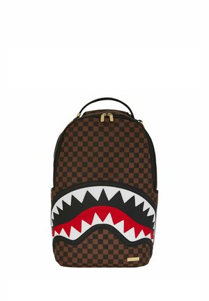 Zaino a quadri marrone con un grande design di bocca di squalo in bianco, rosso e nero. Include zip dorate e una maniglia sulla parte superiore.