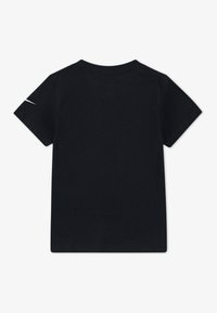 Μαύρη βαμβακερή μπλούζα κοντομάνικη με λαιμόκοψη και μια μικρή ανακλαστική λεπτομέρεια στο αριστερό μανίκι. Λείος υφή χωρίς σχέδια.