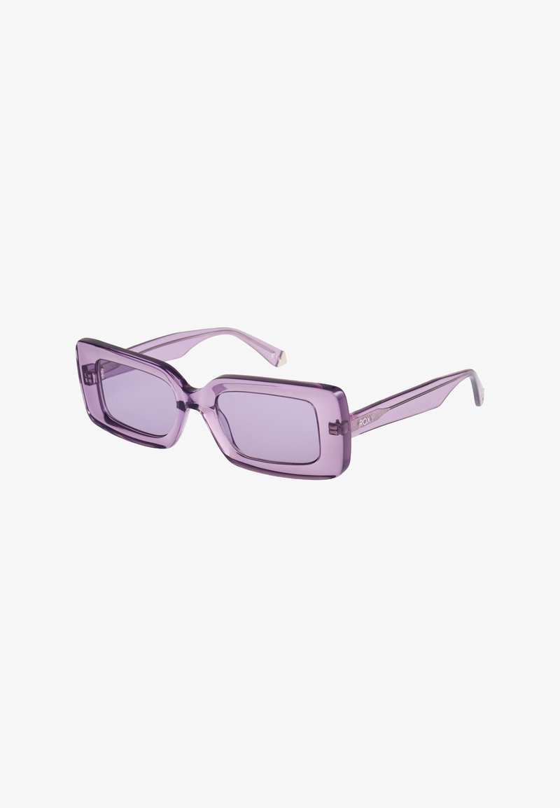Lunettes de soleil rectangulaires violettes avec des montures épaisses translucides et des verres teintés assortis, légèrement inclinées vers la droite.