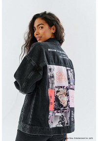 Czarna kurtka dżinsowa o luźnym kroju, z kolażem kolorowych grafik na plecach oraz haftowanym tekstem na kołnierzu.