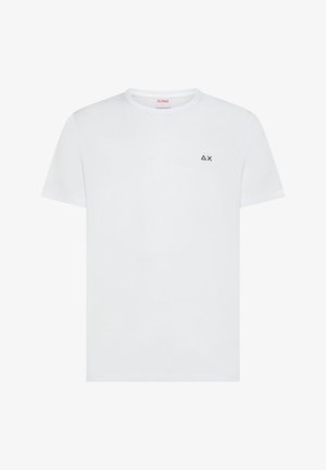 T-shirt bianca a maniche corte con scollo tondo, con piccolo triangolo nero e logo "X" sul petto in alto a sinistra.
