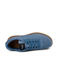 Light blue sneaker with a textured upper, round toe, flat brown rubber sole, lace-up design, and perforated accents on the sides.