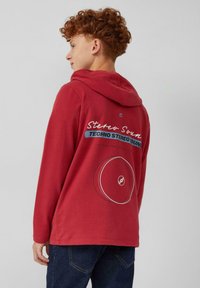 Rode pullover hoodie met een voorzak, met een grafisch ontwerp van een draaitafel en tekst op de rug. Gemaakt van een katoenmix, zachte textuur.