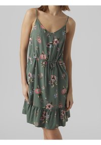 Květinové šaty ze zelené látky s růžovými a modrými květinami, s ramínky na špagety, stahovací pas a volánkový lem.