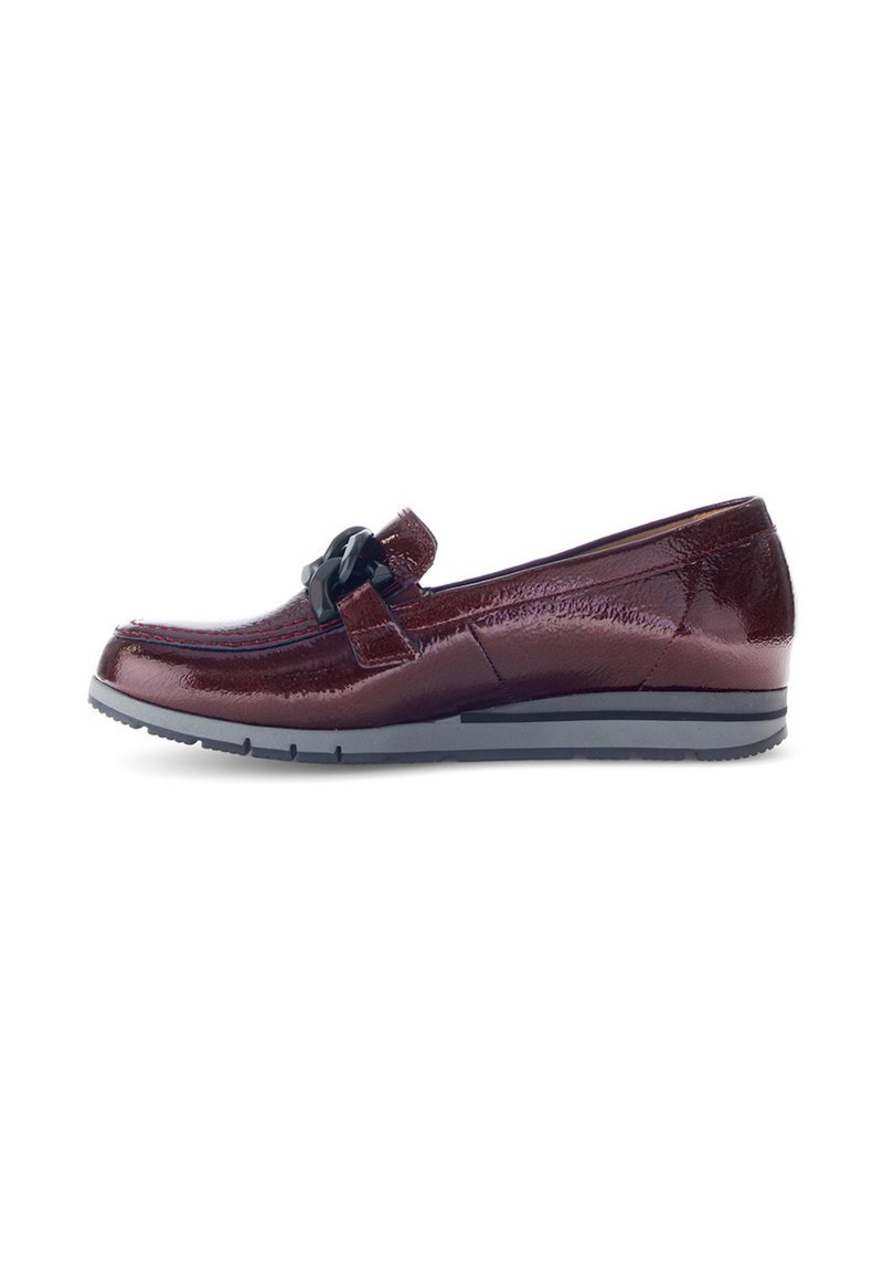 Bordeaux patent leren loafer met een zwarte decoratieve gesp, ronde neus en een lage rubberen zool. Voorzien van rode stiksels langs de naden.