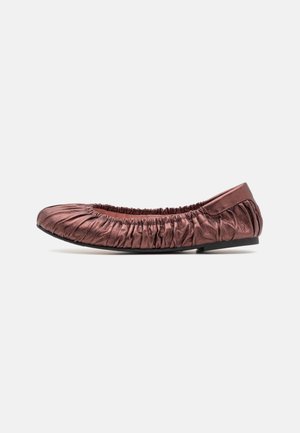 Zapato de ballet plano metálico rosa suave con detalles fruncidos y suela negra, mostrado de perfil sobre un fondo blanco.