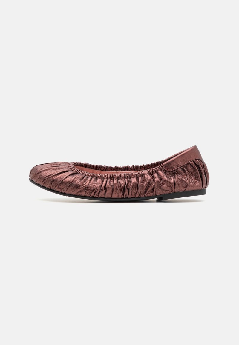 Chaussure de ballet plate métallique rose douce avec détails froncés et semelle noire, présentée de profil sur fond blanc.