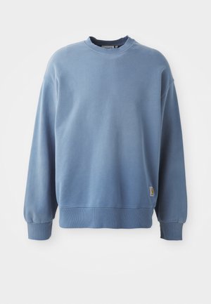 Light blue sweatshirt made of soft fabric, featuring a round neck, long sleeves, ribbed cuffs and hem, with a small logo tag near the bottom.
