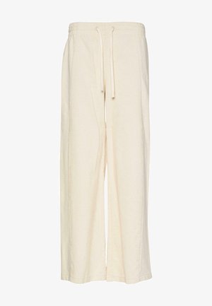Weite Hosen in Creme, aus einem strukturierten Stoff mit einem gerippten Muster. Verfügt über einen elastischen Bund und einen Kordelzug zur Anpassung.