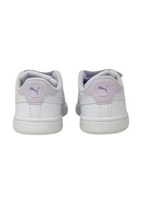 Sneakers bianchi con una finitura in pelle liscia, con un dettaglio del logo viola sulla parte posteriore e un design minimalista. Silhouette arrotondata con accenti testurizzati.