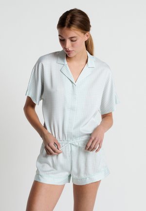 Ensemble de pyjama court en vert menthe clair avec un motif à carreaux. Tissu doux, manches courtes, et une taille élastique avec cordon de serrage.