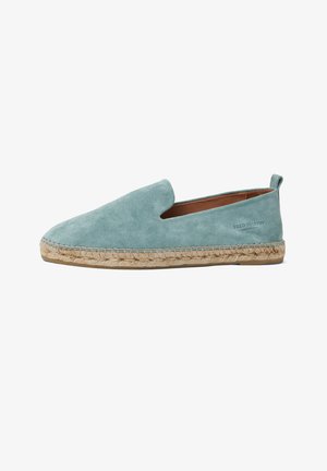 Lichtblauwe suède instap-espadrille met gevlochten jutezool, afgeronde neus en "Fred Martin Collection"-logo aan de zijkant.