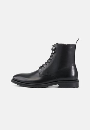Svart lær ankelboot med en jevn finish, rund tå, snøring foran, metalløyer og en holdbar gummisåle.