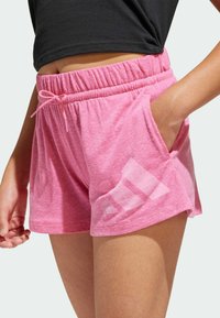 Rosa, lätta shorts med elastisk midja och liten dragsko. Har sidofickor och en diskret logotypdetalj på benet.