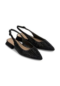 Des chaussures à talons ouverts noires avec un bout pointu, ornées de clous ronds noirs, présentant un petit talon bloc et des bords festonnés.