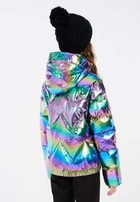 Iridescentní puffer bunda s geometrickým prošíváním, vybavená kapucí a elastickým lemem. V kombinaci s černou pletenou čepicí.