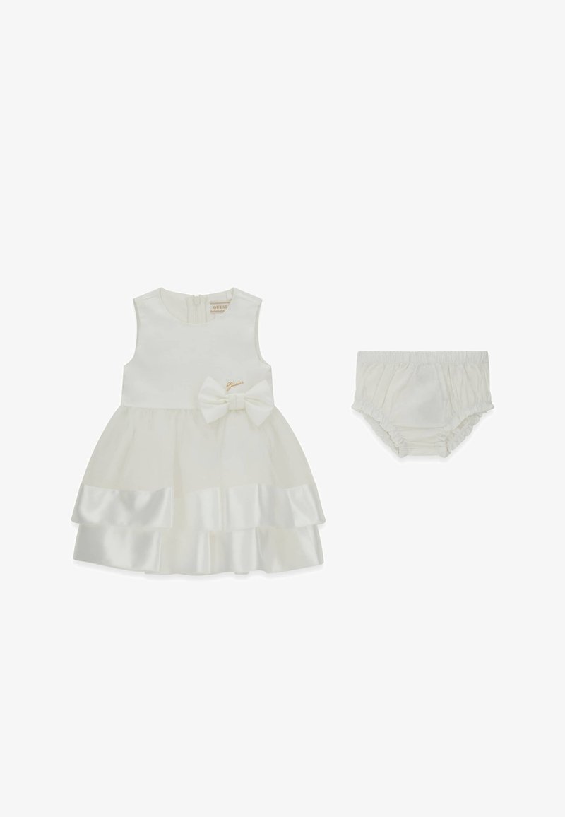 Weißes ärmelloses Kleid mit mehrlagigem Satinstoff-Rock, Schleifendetail und goldenem Logo. Inklusive passender weißer Bloomer.