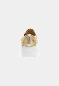 Sneaker in tessuto dorato con collare imbottito, accenti metallici e suola bianca chunky. Logo del marchio impresso di lato.