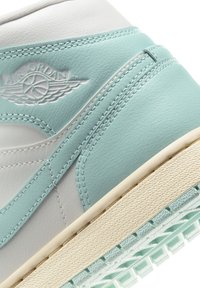 Air Jordan tenisice s bijelim kožnim gornjim dijelom i mint zelenim naglascima, teksturiranom površinom, detaljem loga i kremastom gumenom potplatom.