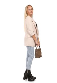 Blazer beige ajusté avec des manches retroussées, jean bleu clair et bottines noires à talons. Tient un sac à main marron au fini lisse.