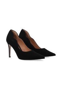 Black suede high heels with pointed toes, scalloped cutouts on the sides, and a slim stiletto heel. Smooth interior lining.