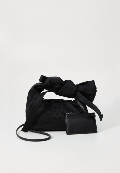 Sort nylon spandbucket bag med knyttede top-håndtag, præget logo og en aftagelig kortholder i sort læder. Glat tekstur og minimalistisk design.