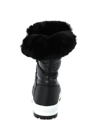 Bota de invierno negra con grueso puño de pelo, parte superior acolchada y suela blanca, vista desde atrás sobre un fondo blanco.