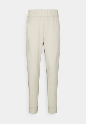 Beige sweatpants met een elastische tailleband, taps toelopende benen, zijzakken en ribbelmanchetten. Glad stof met subtiele textuur.