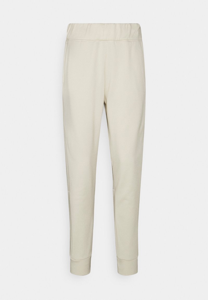 Beige sweatpants met een elastische tailleband, taps toelopende benen, zijzakken en ribbelmanchetten. Glad stof met subtiele textuur.