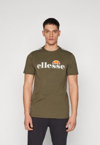 Olive green cotton t-shirt featuring a white "ellesse" logo, a red and yellow graphic, and white stripes on the shoulders. Short sleeves.