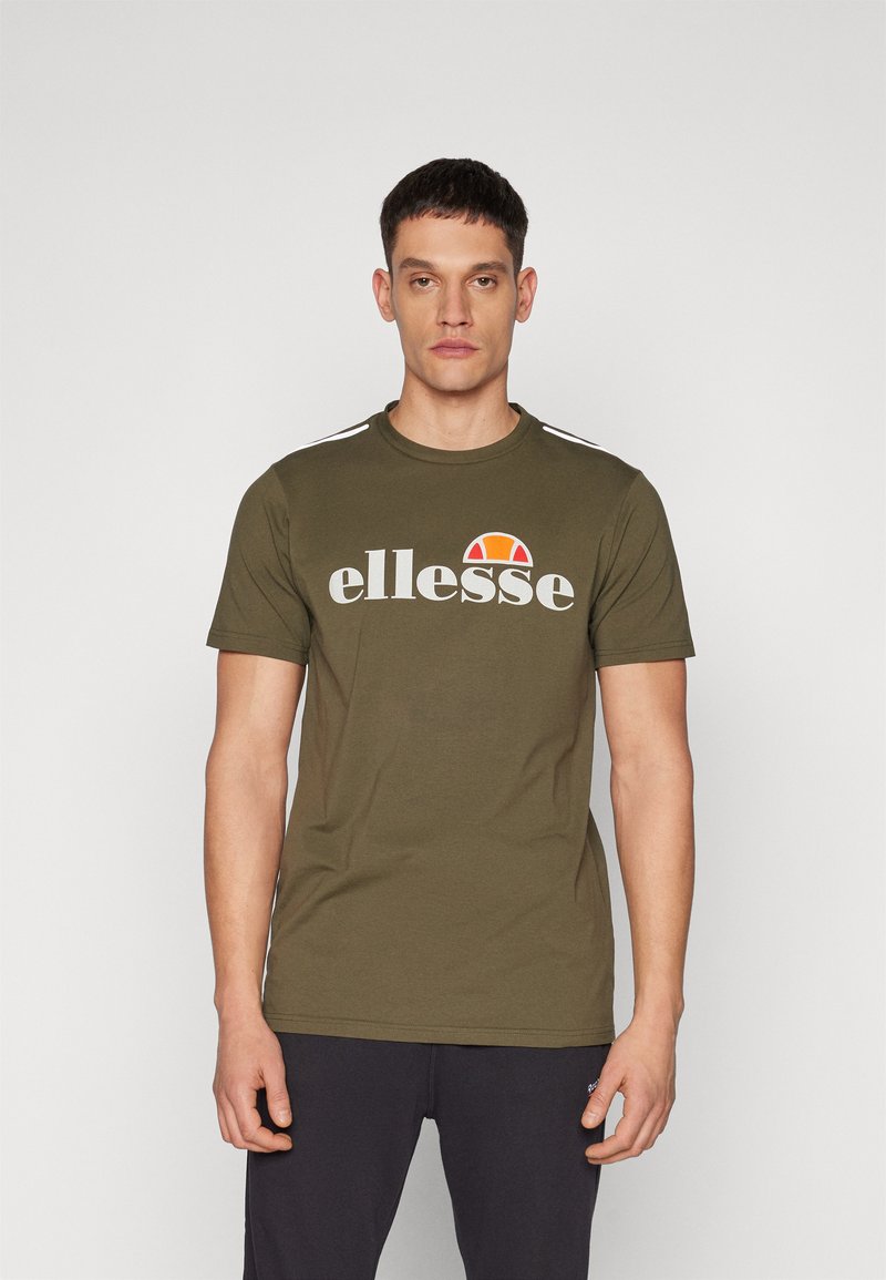 Olive green cotton t-shirt featuring a white "ellesse" logo, a red and yellow graphic, and white stripes on the shoulders. Short sleeves.