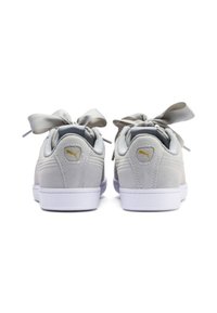 Jasnoszare sneakersy Puma z grubymi satynowymi sznurówkami, oglądane od tyłu na białym tle.