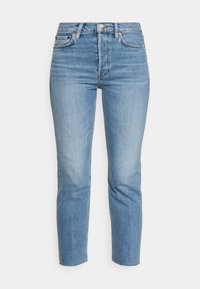 Vaqueros de denim de color azul claro con cintura alta, corte ajustado, perneras rectas y desvanecimiento mínimo. Cuenta con un diseño clásico de cinco bolsillos y remaches de metal.