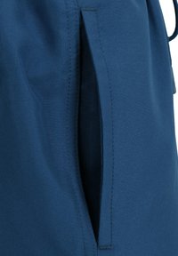 Nahaufnahme einer Schlitztasche auf blauer Stoff mit sichtbaren Nähten entlang der Taschenkanten.