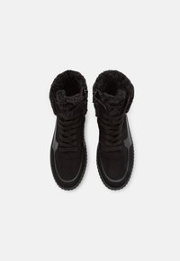 Bottes cheville noires doublées en fausse fourrure, en suède, avec un bout rond et une semelle en caoutchouc. Lacets à l'avant et fermeture éclair latérale pour un enfilage facile.