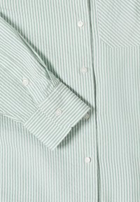 Chemise à manches longues à rayures verticales vert clair et blanc, avec poignets boutonnés, boutons sur le devant et une poche poitrine.