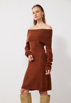 Off-the-shoulder jurk met lange mouwen in rustkleurige gebreide stof met een aansluitende silhouet. Ribbelstructuur, lengte tot halverwege het bovenbeen, eenvoudig ontwerp.