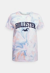 Camiseta de manga corta con un patrón de mármol multicolor, que presenta un logo en azul marino de "HOLLISTER" y un emblema de ave en la parte delantera. Material de algodón.
