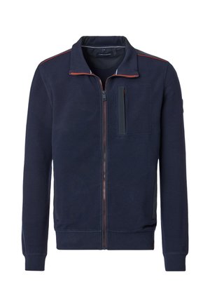 Veste zippée navy en tissu texturé. Dotée d'un col montant, d'une poche poitrine et de coutures rouges contrastantes le long du zip.