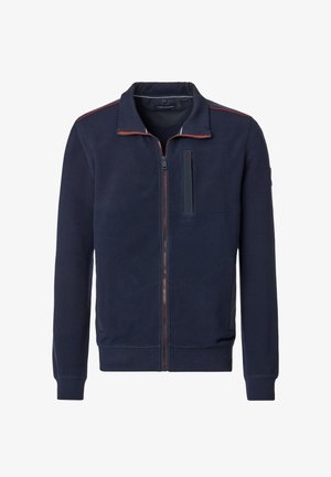 Marineblå zip-up jakke lavet af tekstureret stof. Har en stående krave, en brystlomme og kontrasterende rød syning langs lynlåsen.