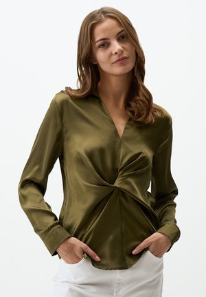 Olijfgroene satijnen blouse met een v-hals en een gedraaide voorkant. Lange mouwen met knoopmanchetten. Glad textuur, getailleerde silhoet.