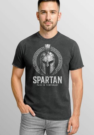 Black cotton t-shirt featuring a distressed Spartan helmet graphic and white text reading "SPARTAN PAIN IS TEMPORARY." Casual fit with short sleeves.